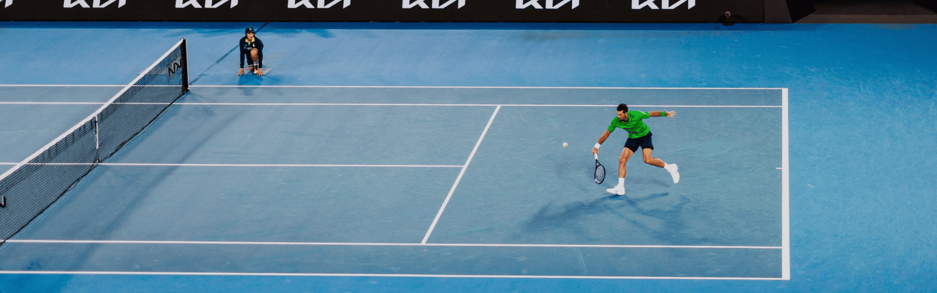 Tennis player on blue court.